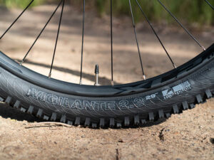 A Mountain wheelset shows the bike spoke, nipple, and valve