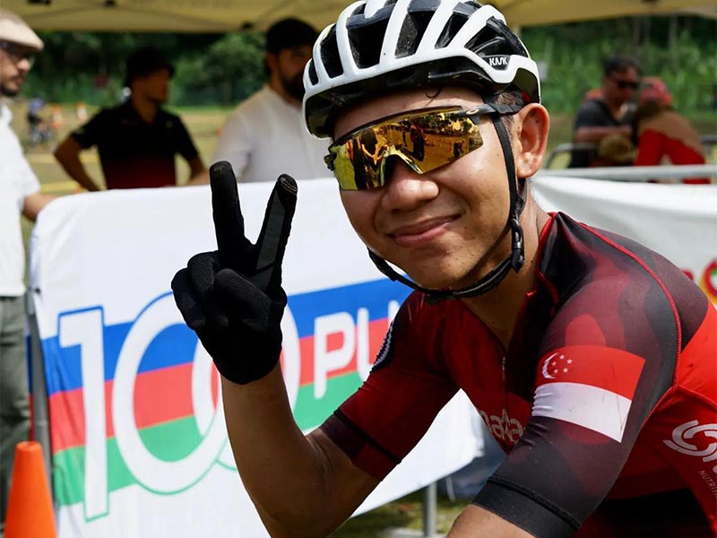 Singaporean cycling athlete, Arfan flashes a peace sign while smiling at the camera