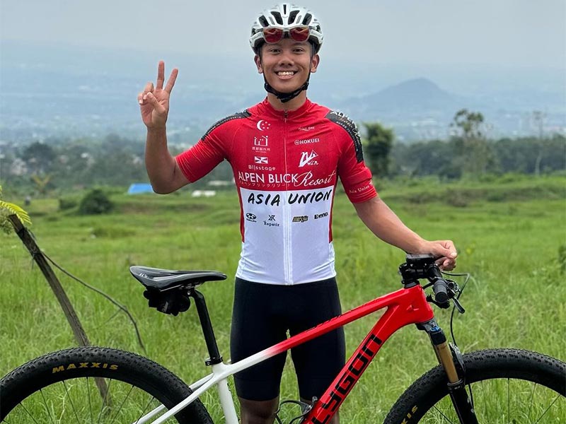 Singaporean cycling athlete, Riyad flashes a peace sign while smiling at the camera