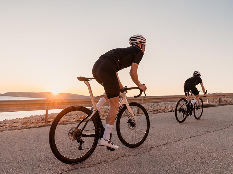 A road cyclist is enjoying the sunset on their racing bike