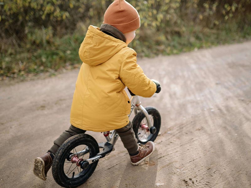 A child is riding a balance bike